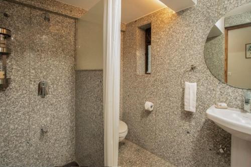 a bathroom with a sink and a toilet and a mirror at ama stays & trails - Dulwich Park View in Panchgani