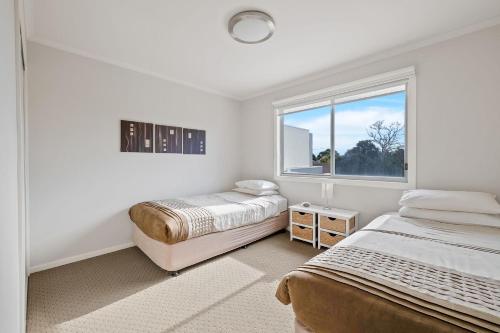 Un dormitorio con dos camas y una ventana. en Island Oasis, en Cowes