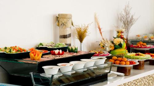 a buffet with vegetables and fruits on a table at Seaside Boutique Resort Quy Nhon in Quy Nhon