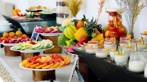 a buffet of fruits and vegetables on plates on a table at Seaside Boutique Resort Quy Nhon in Quy Nhon