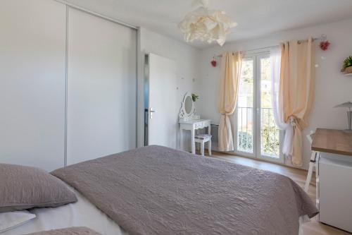 - une chambre blanche avec un lit et une fenêtre dans l'établissement La Petite Poule Rousse - Maison avec piscine, à Anduze