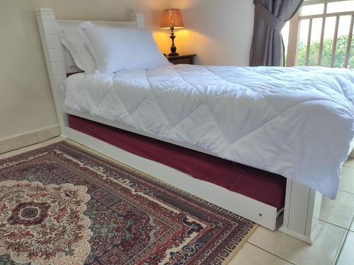 a bedroom with a white bed with a rug at Sofea Inn Bukit Merah - Suria A7733 in Kampong Selemat