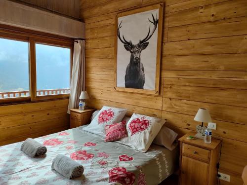 - une chambre dotée d'un lit avec une photo de cerf sur le mur dans l'établissement Chambres d'hôtes Le Grand Chalet, à Valdeblore