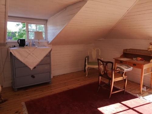 Cette chambre mansardée comprend un bureau et une chaise. dans l'établissement Stockholm B&B Cottage, à Nacka