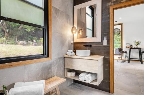 bagno con lavandino e specchio di Gan Eden Retreat-Byron bay , luxuries escape a Mullumbimby