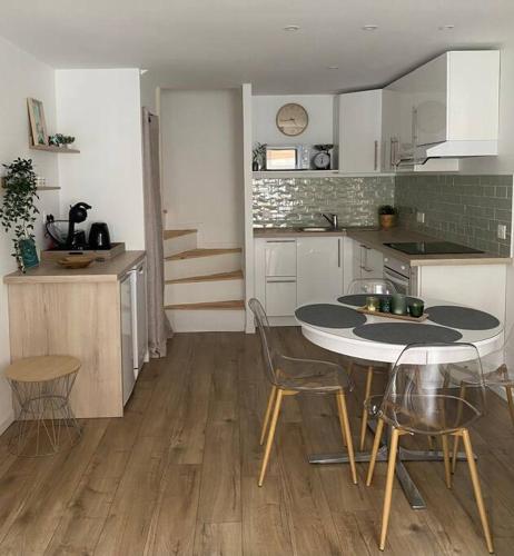 une cuisine avec une table et des chaises dans une pièce dans l'établissement La maison près du port, à Fécamp