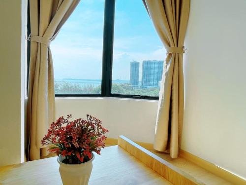 a vase sitting on a table in front of a window at Mutiara Melaka Beach Resort by Minso in Tangga Batu
