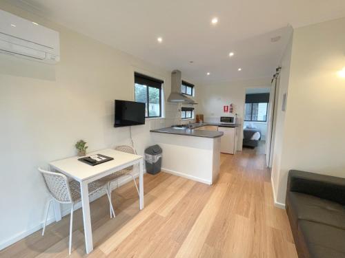 a kitchen and living room with a white table and chairs at Breeze Holiday Parks - Grampians in Halls Gap