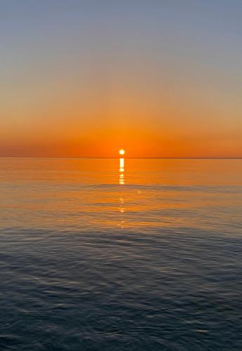 a sunset over the ocean with the sun setting at Il Moro in Carini