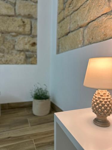 a lamp on a table in a room with a stone wall at Il Moro in Carini