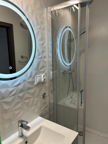 ステグナにあるStegna Apartの洗面台と鏡付きシャワーを備えたバスルーム
