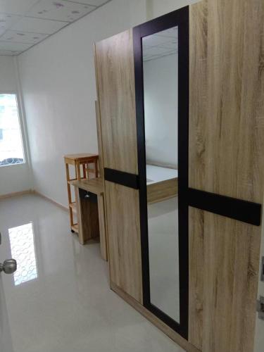 eine Holztür mit einem Spiegel im Zimmer in der Unterkunft 229 White House in Ban Khlong Yuan
