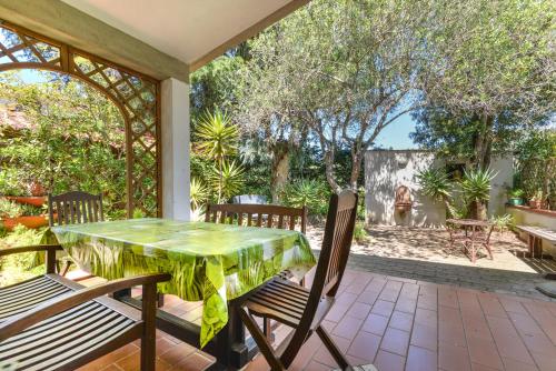 a patio with a green table and chairs at Casa Neda in Procchio