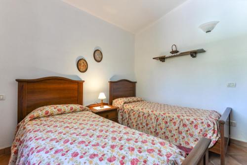 a bedroom with two beds and two clocks on the wall at Casa Neda in Procchio