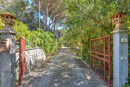 an empty street with an orange gate and trees at Casa Neda in Procchio
