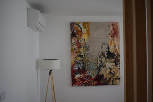 a painting hanging on a wall next to a lamp at Casa dos Picoutos AL in Monção