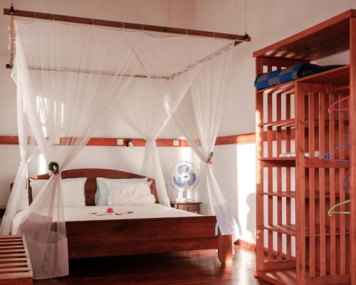 a bedroom with a bed with a canopy at Hotel Ambalakely in Ambalakely