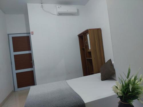 a bedroom with a bed and a door with a window at HAPDESKO HOMESTAY in Batam Center