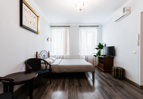 um quarto com uma cama, uma mesa e uma televisão em Апартаменты в центре Киева на Бессарабской Площади 7 em Kiev