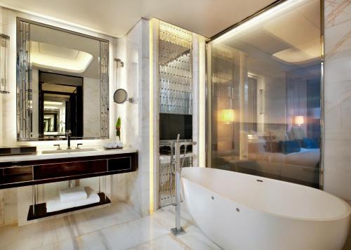 a bathroom with a tub and a sink and a mirror at The St. Regis Shenzhen in Shenzhen