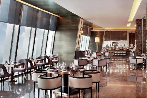 a restaurant with tables and chairs and windows at The St. Regis Shenzhen in Shenzhen