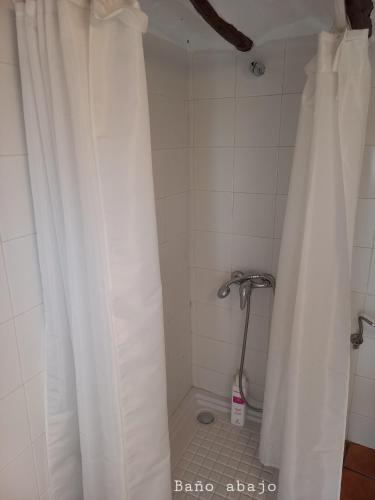 a shower with a white shower curtain in a bathroom at Casa del Puente in Nerpio