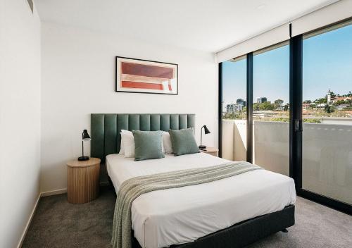 a bedroom with a bed and a large window at Rambla at Perry House in Brisbane