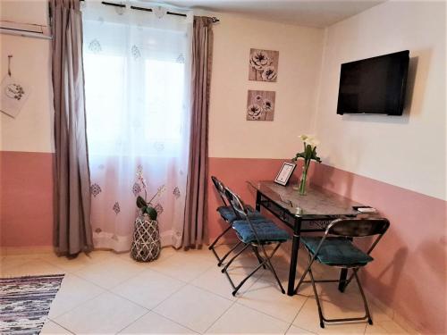 a dining room with a table and chairs and a television at Montenegro Smile in Dobra Voda