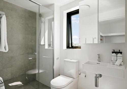 a bathroom with a toilet and a sink and a shower at Rambla at Perry House in Brisbane