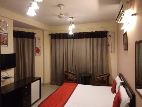 Dormitorio con cama, escritorio y TV en first choice guest house pvt ltd, en Gurgaon