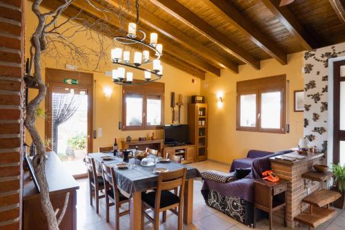 a dining room with a table and chairs and a living room at La teuleria de linyola in Linyola