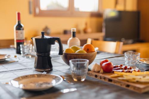 a table with a bottle of wine and a bowl of fruit at La Teuleria de Linyola in Linyola
