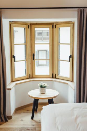 a room with a table and two windows at Hotel Schmuckhof in Chiusa
