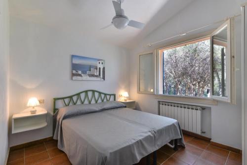 un dormitorio con una cama y una ventana en Appartamento La Spiga, en Procchio