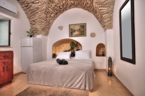 a bedroom with a large bed with a stone wall at בראשית - סוויטות בוטיק בצפת העתיקה - Beresheet - Boutique Suites in the Old City in Safed