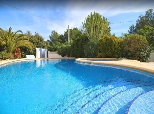 una gran piscina de agua azul en un patio en Villa totalmente independiente con piscina comunitaria, en Calpe