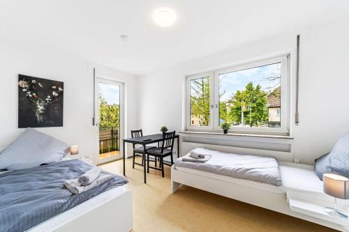 a bedroom with a bed and a table and windows at MONTEURWOHNUNG Göppingen GP04 RAUMSCHMIDE Apartments in Göppingen