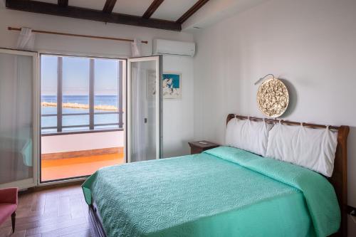 a bedroom with a bed with a view of the ocean at Vero Sicily - Villa San Giorgio in Cinisi