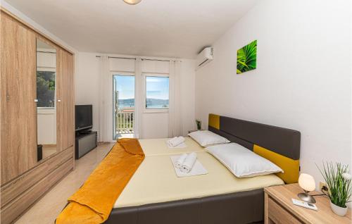1 dormitorio con 1 cama grande y TV en Gorgeous Apartment In Kastel Sucurac With House Sea View, en Kaštela