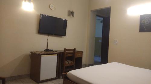 1 dormitorio con 1 cama y TV de pantalla plana en first choice guest house pvt ltd, en Gurgaon
