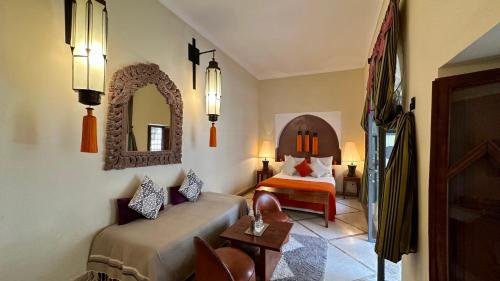 Habitación de hotel con cama y espejo en Riad Jardin Des Rêves, en Marrakech