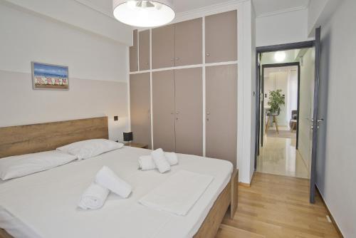 een slaapkamer met een wit bed en handdoeken bij Blue Dream in Piraeus