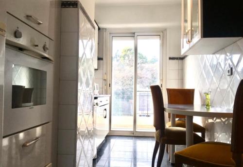 eine kleine Küche mit einem Tisch und einem Fenster in der Unterkunft Grand appartement proche Promenade in Nizza