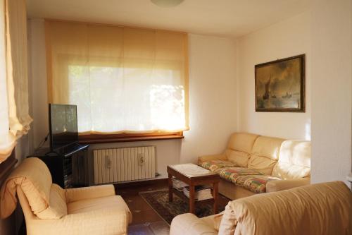 - un salon avec deux canapés et une télévision dans l'établissement Rose Apartment, à Aoste
