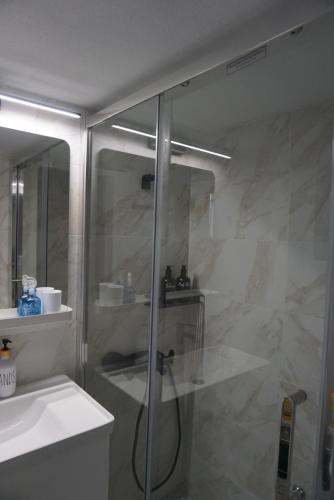 a bathroom with a glass shower and a sink at Alma Sea House in Hanioti