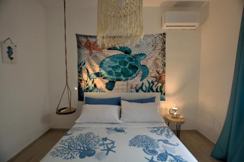 una camera da letto con un letto con arazzo di tartaruga sul muro di Villa Colapesce a Marzamemi