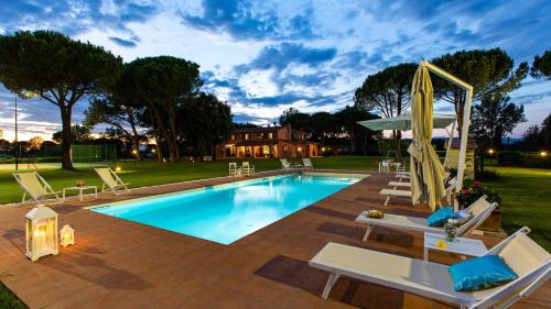 a swimming pool with lounge chairs and an umbrella at Villa Elisa 16, Emma Villas in Fucecchio