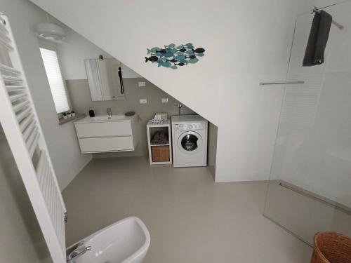 een badkamer met een trap met een wastafel en een wasmachine bij Santa Chiara NUOVO Appartamento in centro di Bra in Bra