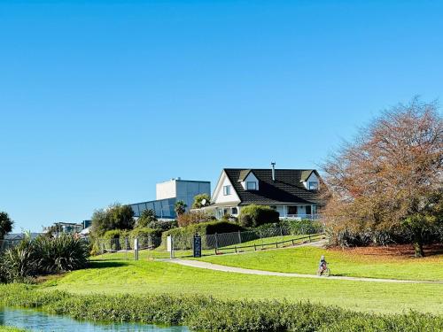 a person walking along a path next to a house at River Cottage in Blenheim