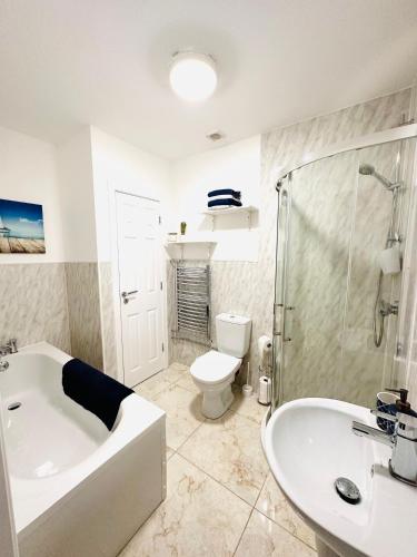 uma casa de banho com uma banheira, um WC e um lavatório. em Robins Cottage 
